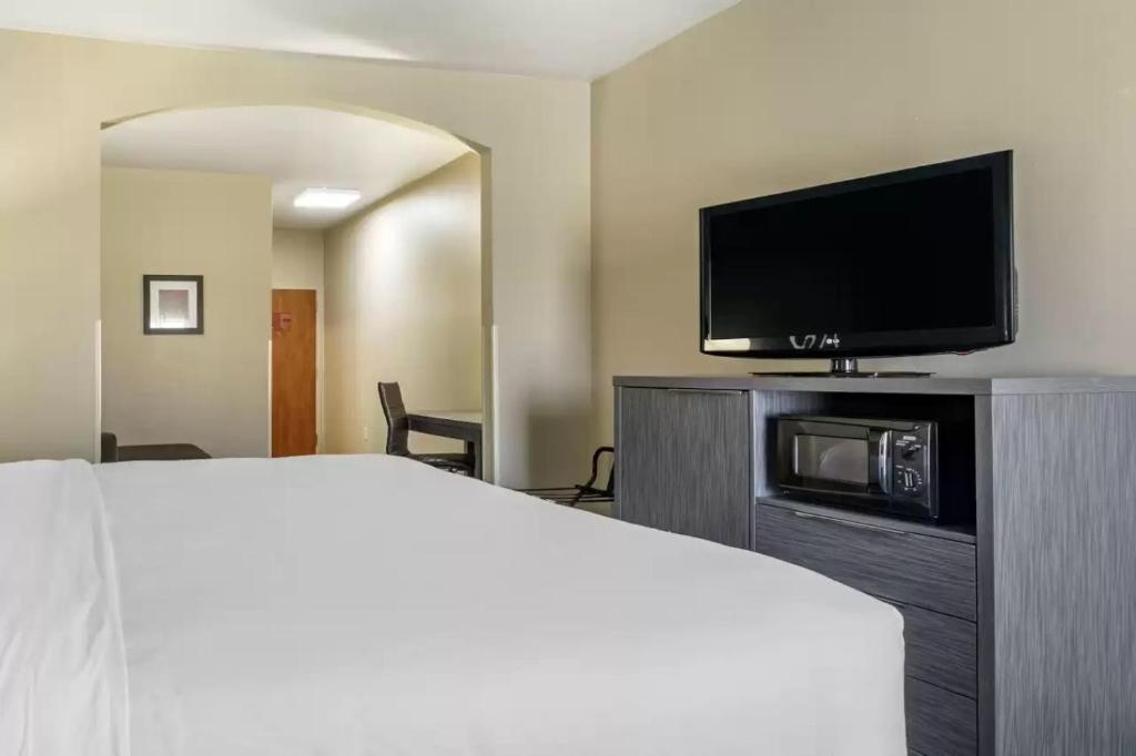 a hotel room with a bed and a flat screen tv at Comfort Inn & Suites Pauls Valley - City Lake in Pauls Valley