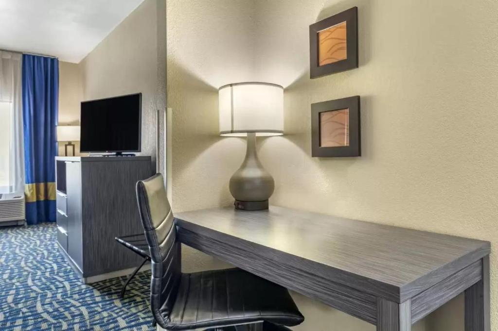 a desk with a lamp and a chair in a hotel room at Comfort Inn & Suites Pauls Valley - City Lake in Pauls Valley