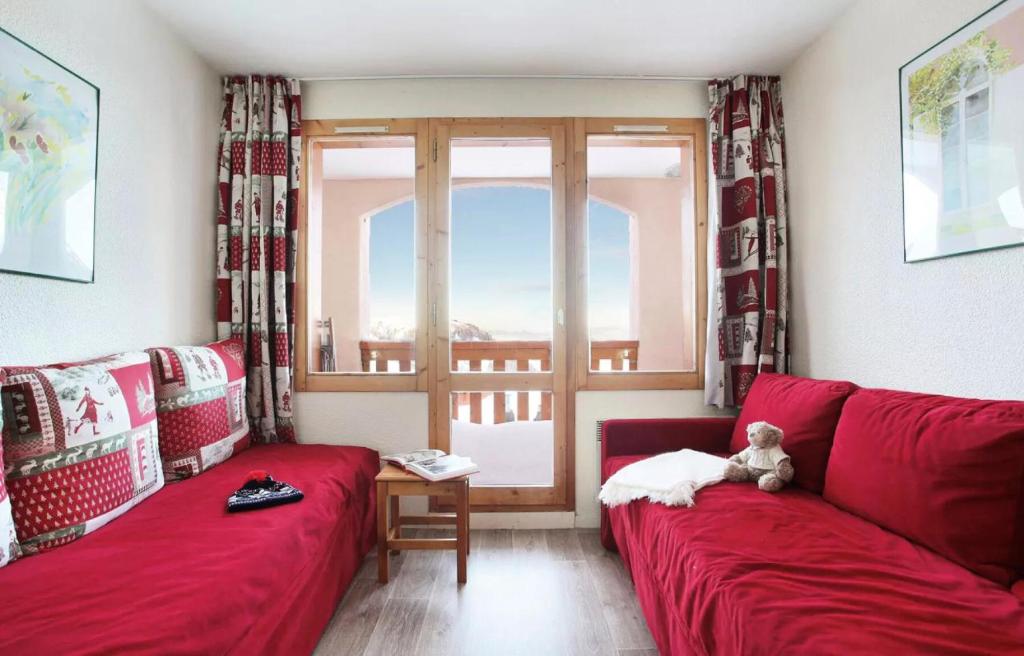 - un salon avec un canapé rouge et une fenêtre dans l'établissement Résidence La Licorne - maeva Home - Studio 4 personnes - Confort MAE-8701, à La Plagne