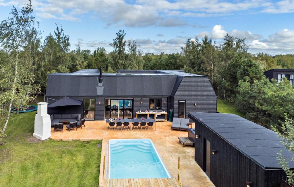 a house with a swimming pool in the backyard at Lovely Home In Væggerløse With Sauna in Marielyst