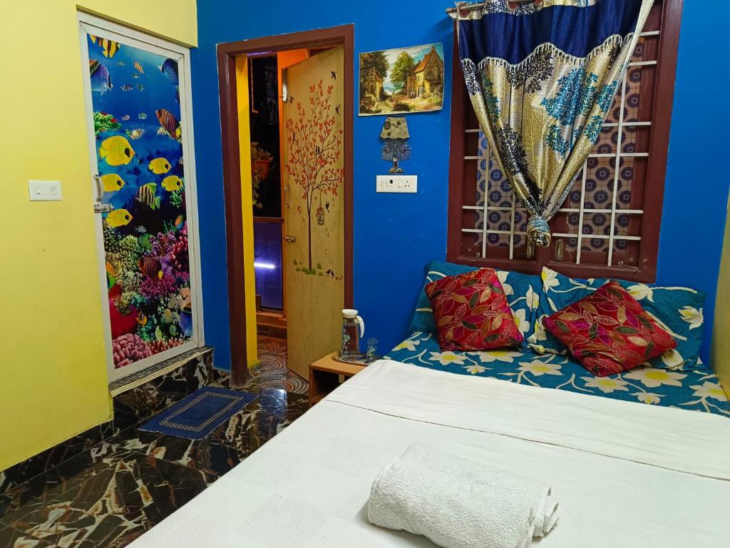 a bedroom with a bed and a blue wall at La Baie Homestay in Puducherry