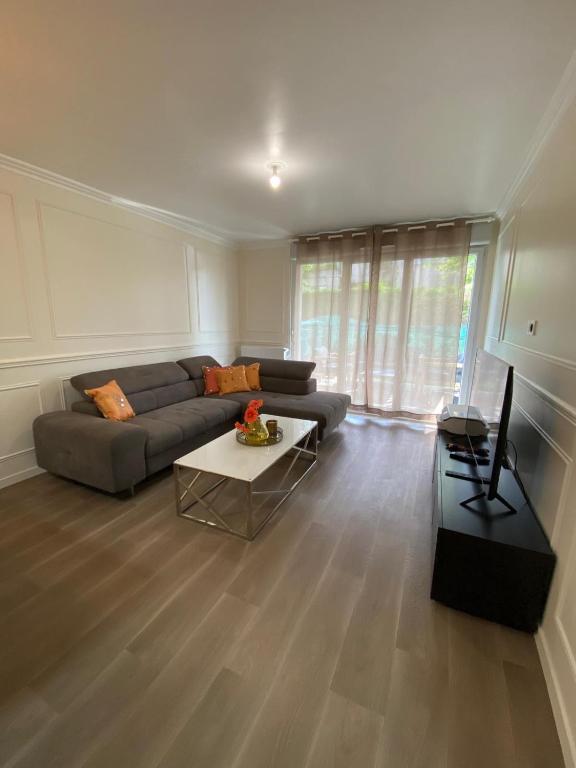 un salon avec un canapé et une table dans l'établissement 2 Bedroom Apartment with garden, à Livry-Gargan