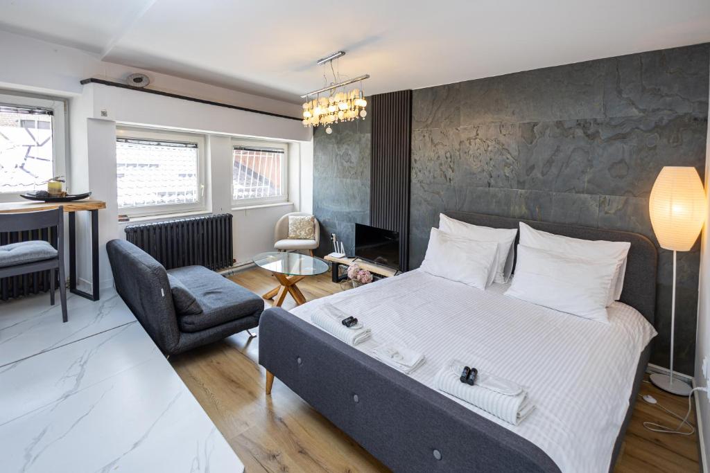 une chambre avec un grand lit et une chaise dans l'établissement Bascarsija Corner, à Sarajevo