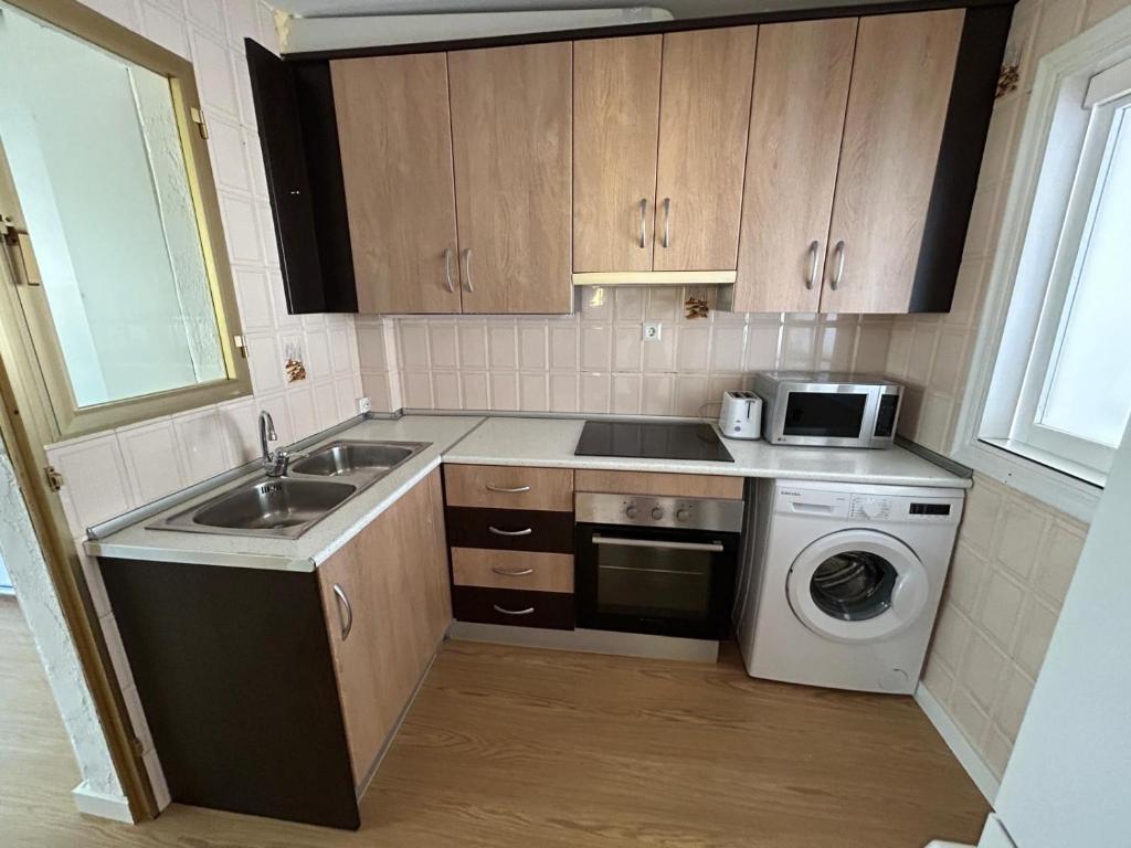 a kitchen with a sink and a washing machine at Apartamento los jazmines in Roquetas de Mar