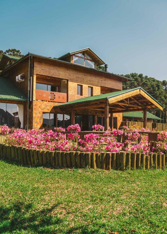 a house with pink flowers in front of it at Parque Nacional EcoResort in Urubici