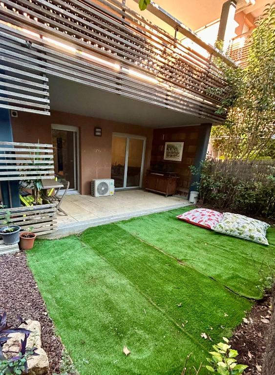une cour avec de l'herbe verte devant une maison dans l'établissement Le petit Cosy Aixois, à Aix-en-Provence