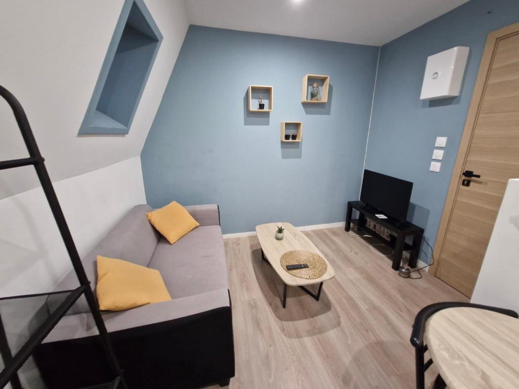 un salon avec un canapé et une télévision dans l'établissement Studio Canada 5, à Valenciennes