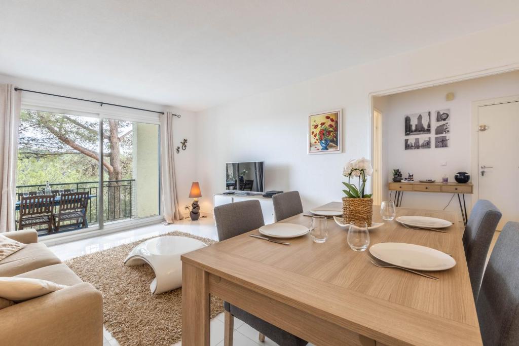 - un salon avec une table à manger et un canapé dans l'établissement LB Vacation Rentals I Spacious 2BR Apartment with Terrace, Balcony, à Mougins
