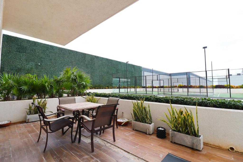 坎昆Luxury Apt with Balcony, Marina Puerto Cancún的阳台上配有桌椅的露台