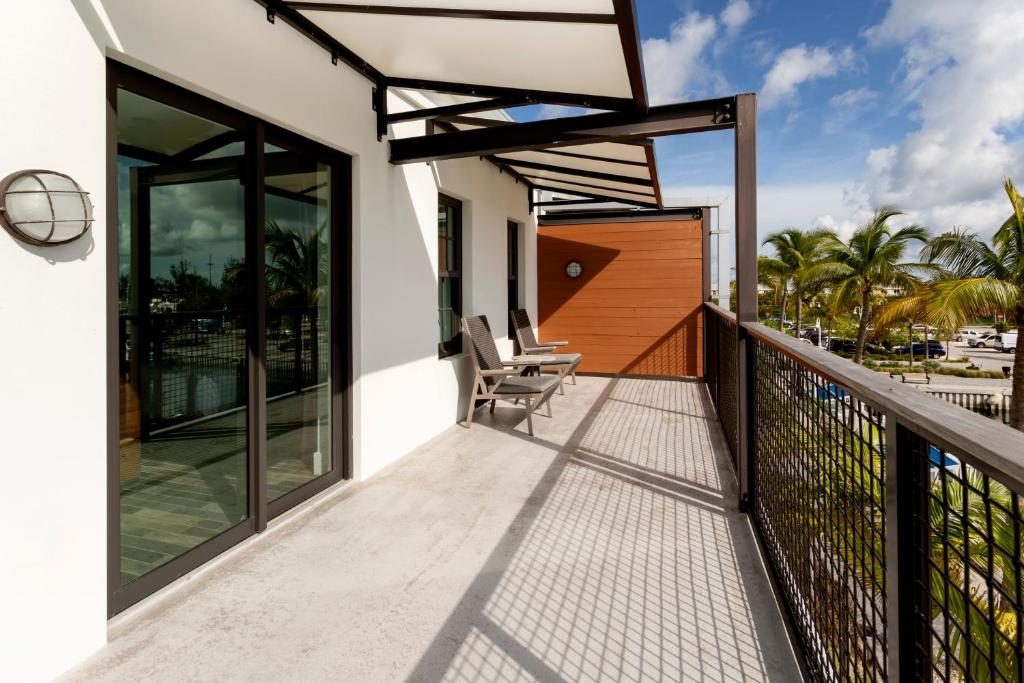 a balcony of a house with two chairs at The Perry Hotel & Marina Key West in Key West