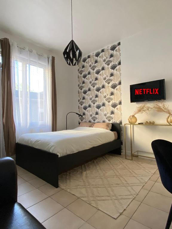 une chambre avec un lit et un panneau sur le mur dans l'établissement Le Cabanon de la Noue, à Conflans-Sainte-Honorine