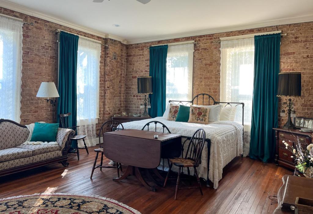 a bedroom with a bed and a table and a couch at Tanglewood Inn in Greenville