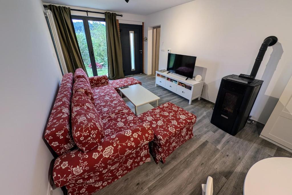 a living room with a red couch and a fireplace at Fuzine Lake Apartments in Fužine