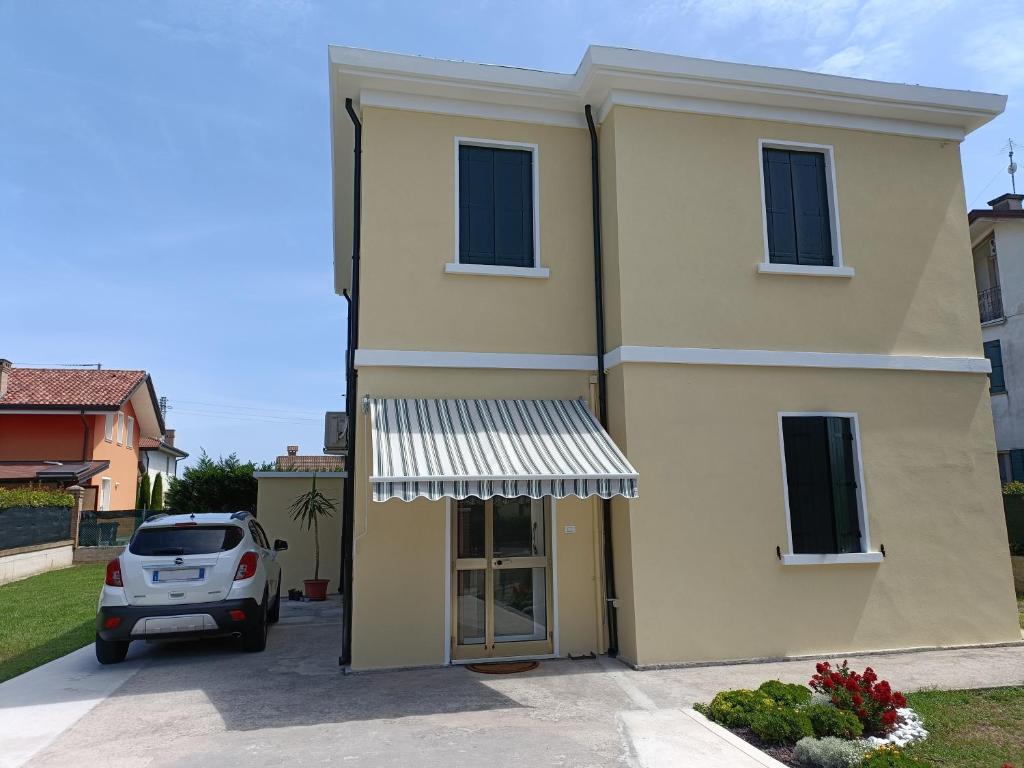 a house with a car parked in front of it at La Casa Gialla in Scardovari