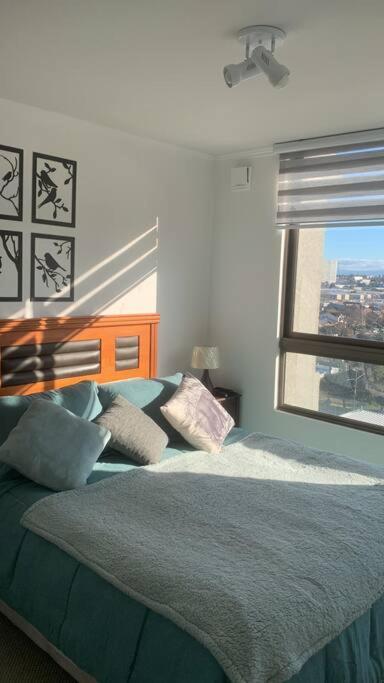 a bedroom with a bed with pillows and a window at Hermoso Departamento en Los Angeles in Los Ángeles