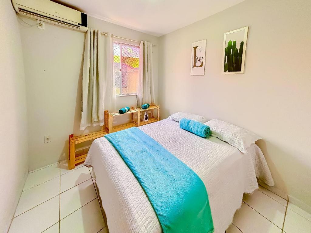a bedroom with a bed with a blue and white blanket at Apê Aconchegante com Piscina I Wi-Fi e A/C in Imperatriz