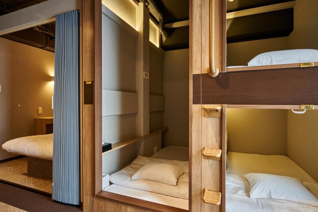 Postel nebo postele na pokoji v ubytování CAPSULE HOTEL CONTINUE NijojoKita