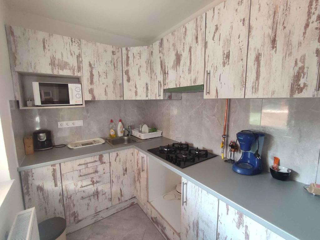 a kitchen with white wooden cabinets and a stove at Holiday home in Siofok - Balaton 51864 in Siófok