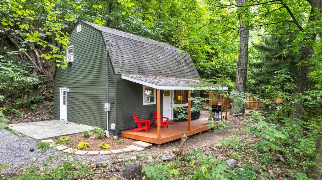 a green tiny house with a deck in the woods at Modern Mountain Cottage w Hot Tub, Fire Pit, WiFi in Inwood