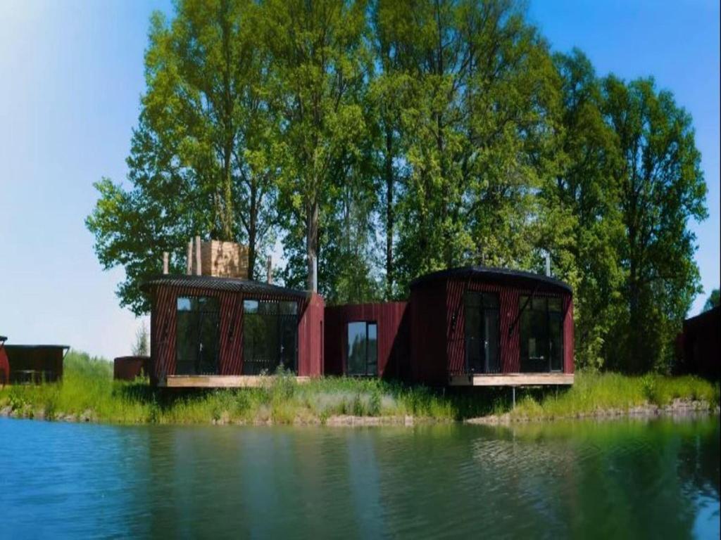 duas casas na margem de um corpo de água em Cozy Bungalow & Shared Pools em Antoing