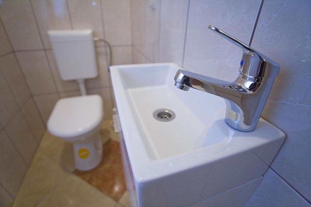 een badkamer met een witte wastafel en een toilet bij Apartments Rubic in Omiš