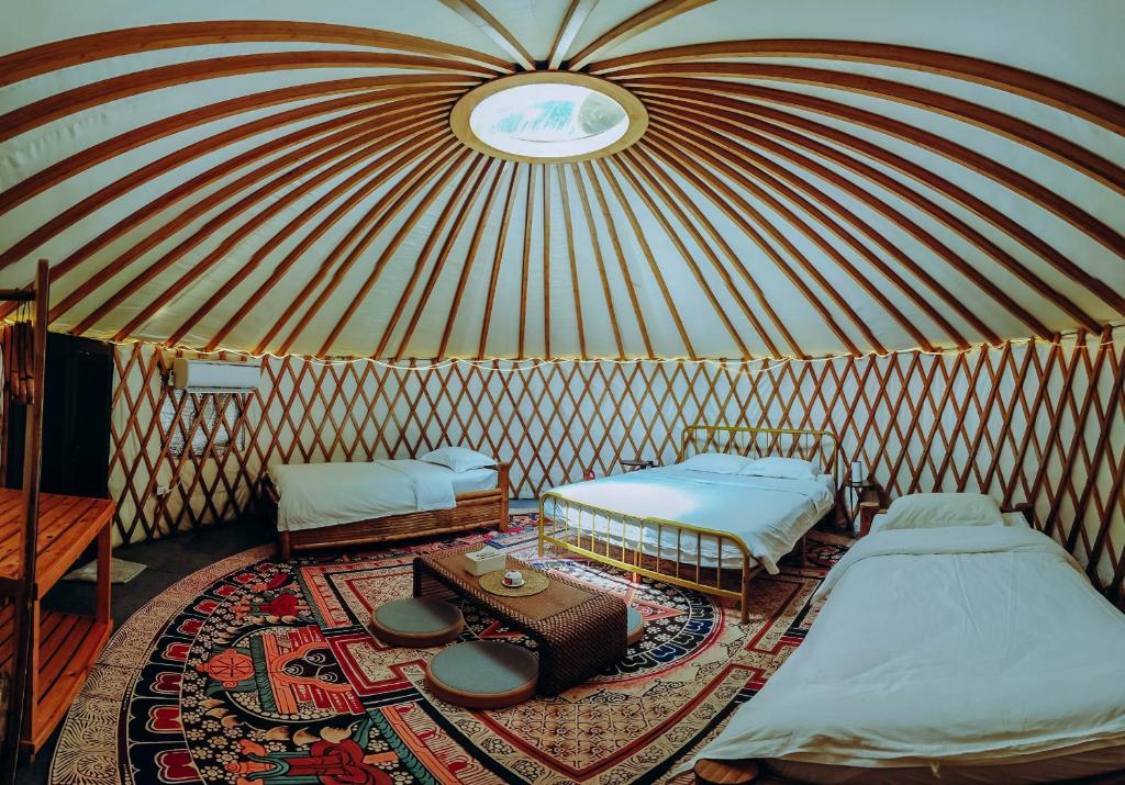 una camera con due letti e un tavolo in una yurta di Nomad Yurts a Coron