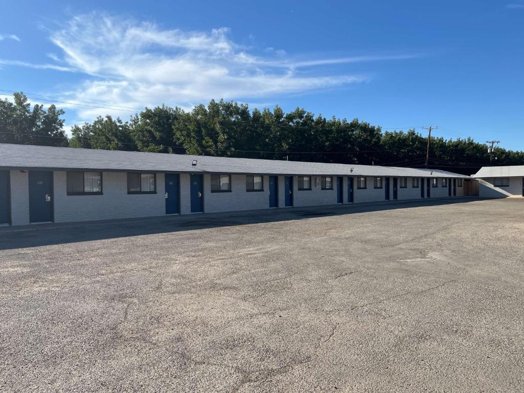 a large white building with a parking lot at Motel 6 Artesia, NM in Artesia