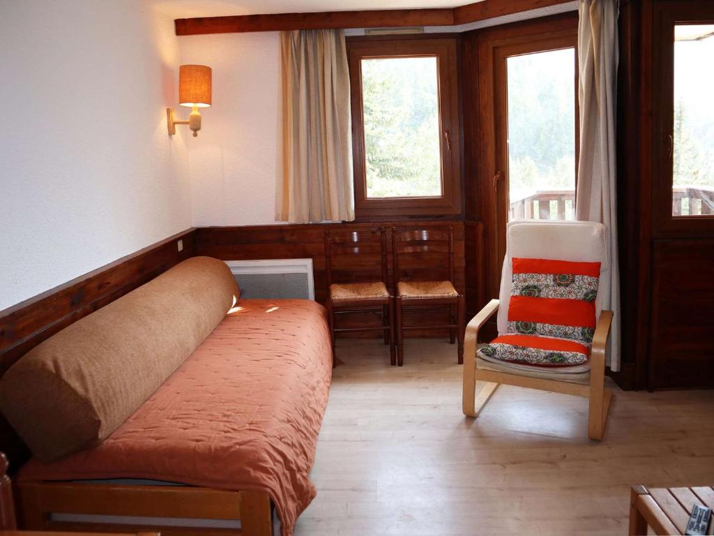 un salon avec un canapé et une chaise dans l'établissement Studio cosy aux Orres, skis aux pieds, balcon, animaux OK - FR-1-322-641, aux Orres