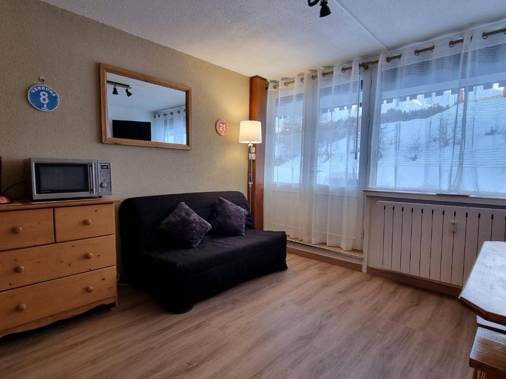 un salon avec une chaise noire et une télévision dans l'établissement Appartement cosy à 100m des pistes, terrasse sud - FR-1-351-224, à La Plagne Tarentaise
