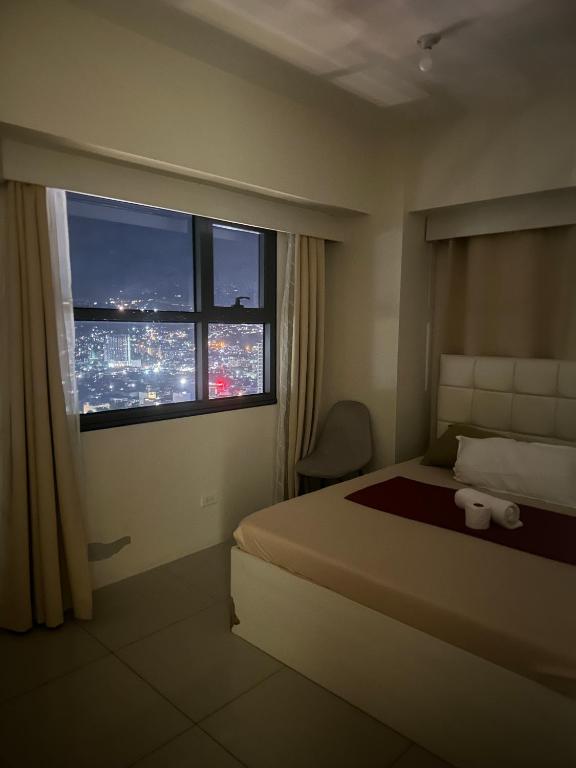 a hotel room with a bed and a window at Jojies Crib Horizons101 2bedrooms in Cebu City