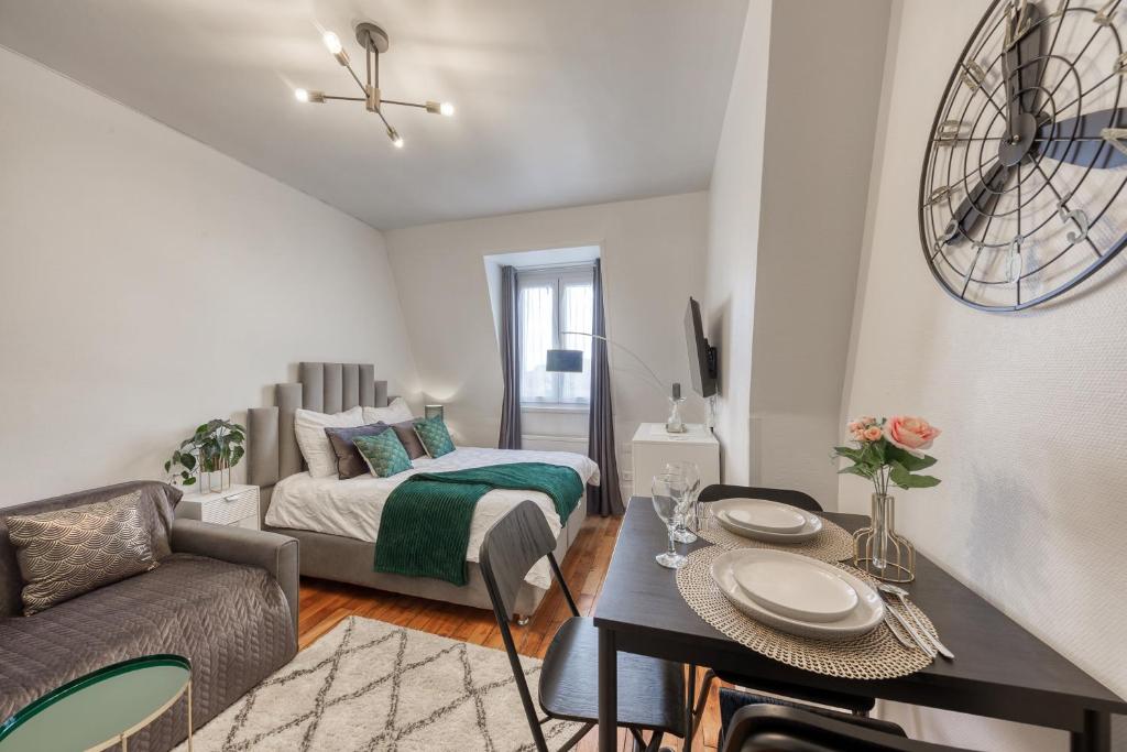 a living room with a bed and a table at Le Cosy ,3 mn de la gare ,Vincennes Porte de Paris in Vincennes