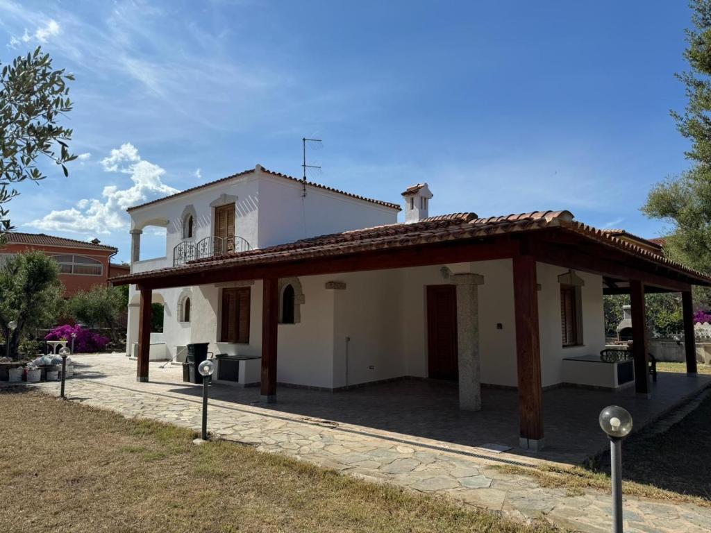 una pequeña casa blanca con techo en San Teodoro centro, en San Teodoro