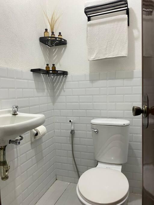 ein weißes Badezimmer mit Toilette und Waschbecken in der Unterkunft Tuyu Homestay in General Luna