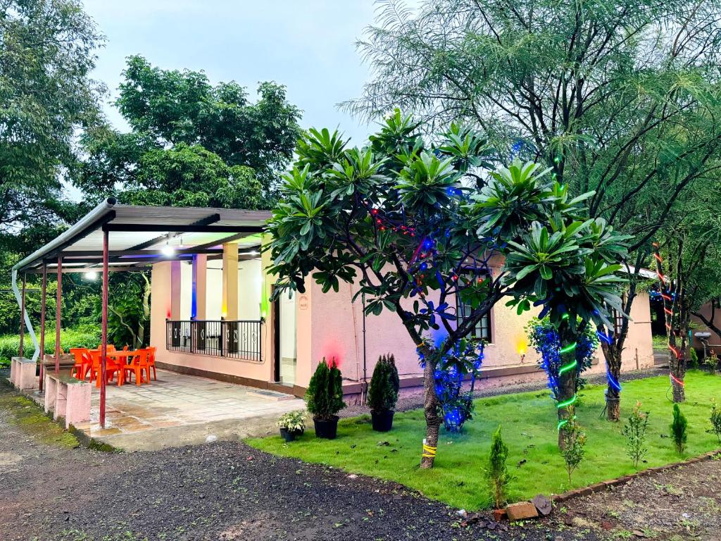 una casa con una mesa y un árbol delante de ella en Rukmini Kunj, en Alibaug