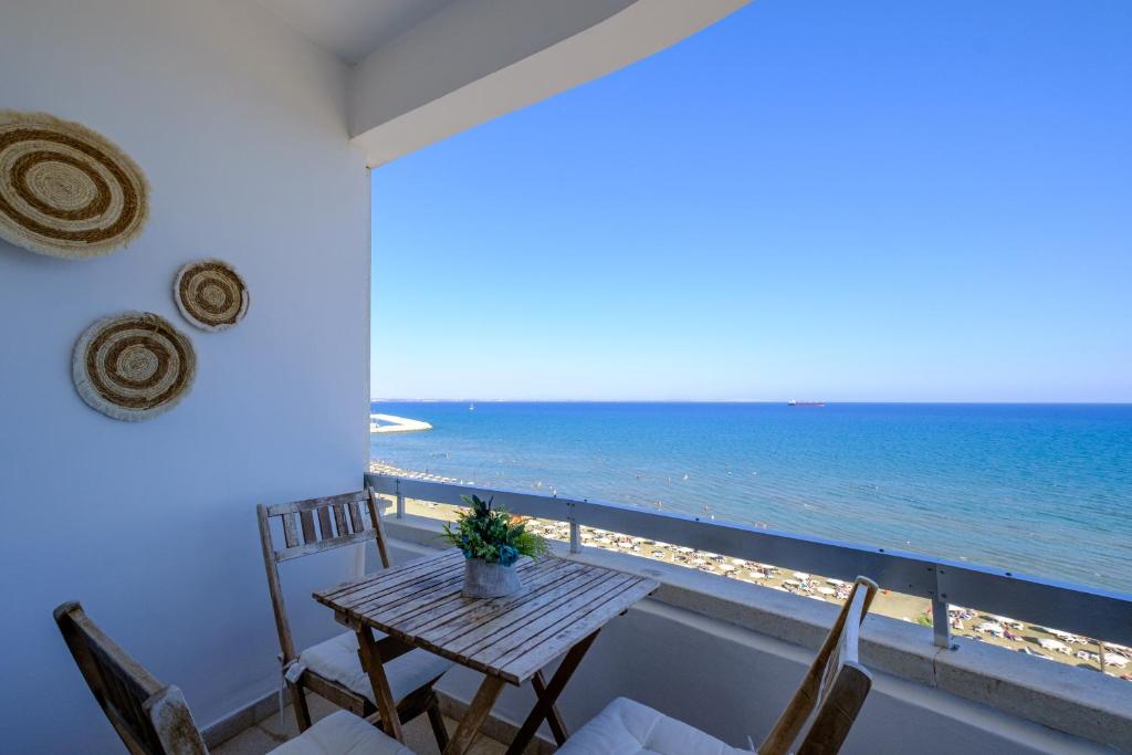 a balcony with a table and chairs and the ocean at Lazuli Sea View Beachfront- Ap 61 in Larnaca