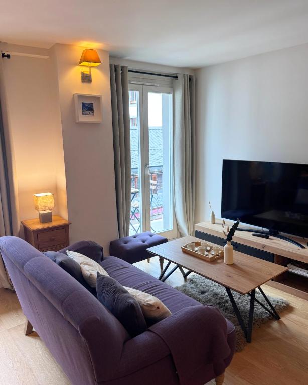 un salon avec un canapé et une télévision dans l'établissement Modern 2-BR in the heart of Chamonix, à Chamonix-Mont-Blanc