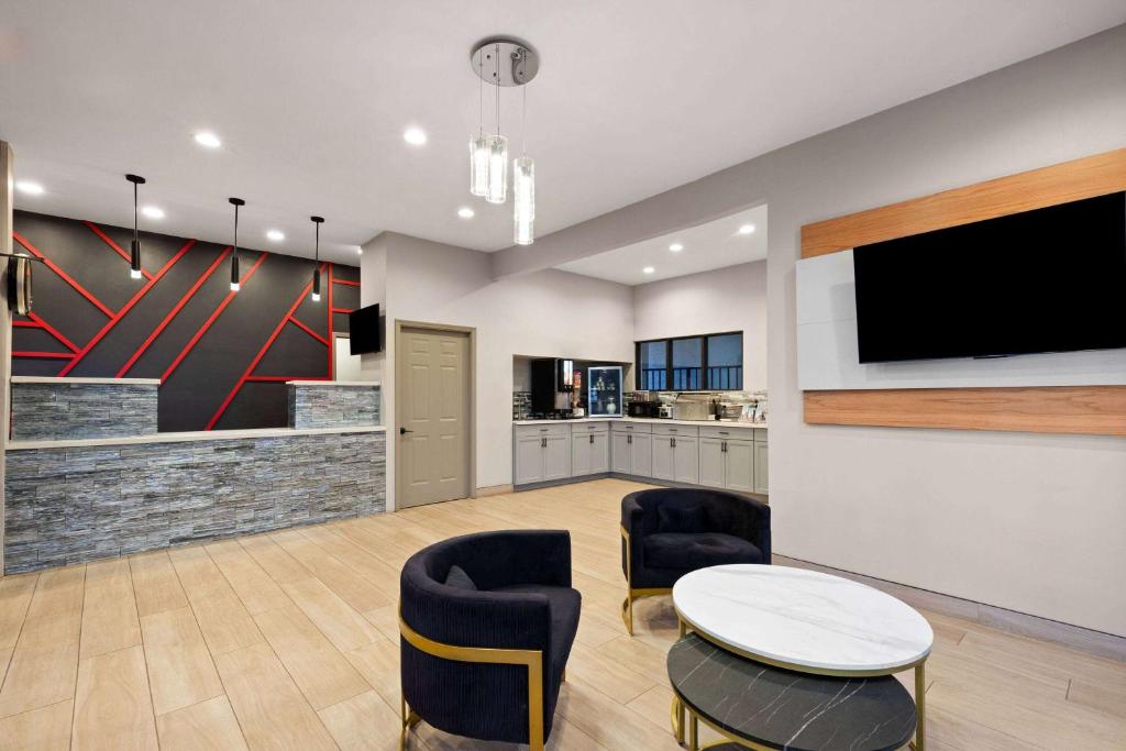 a living room with a tv and a table and chairs at Ramada by Wyndham Bainbridge in Bainbridge