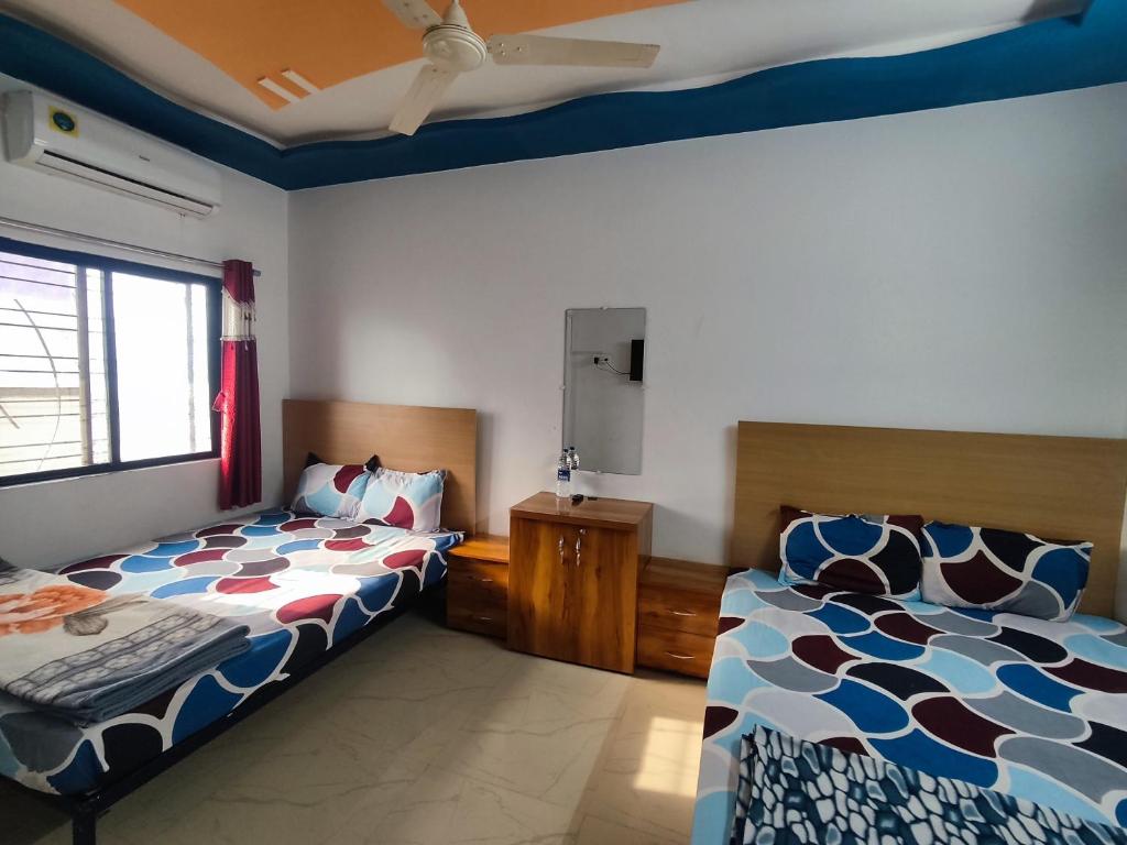 Postel nebo postele na pokoji v ubytování AMBIENT HOME STAY, In Nashik