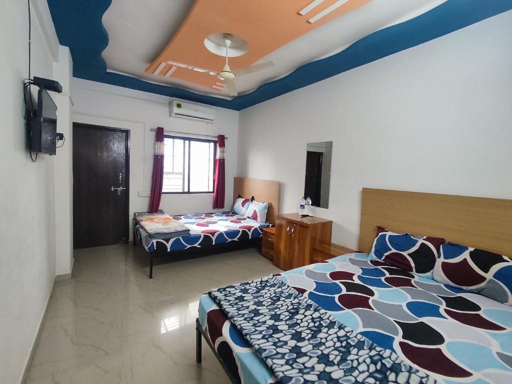 Postel nebo postele na pokoji v ubytování AMBIENT HOME STAY, In Nashik