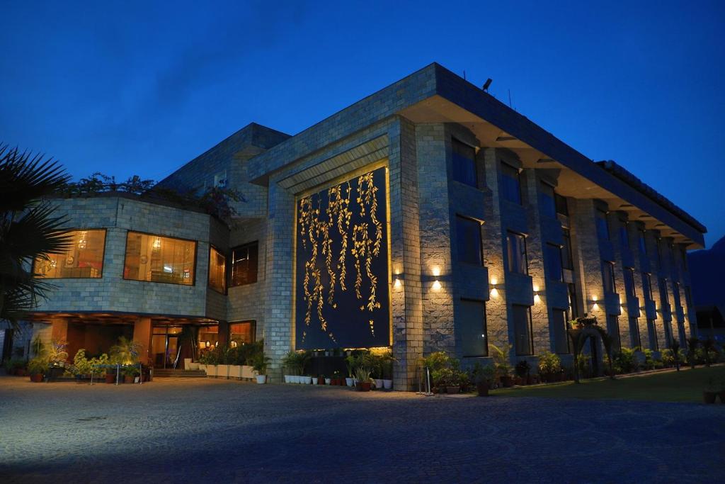 瑞诗凯诗Hotel Natraj Rishikesh的夜晚灯火通明的大楼
