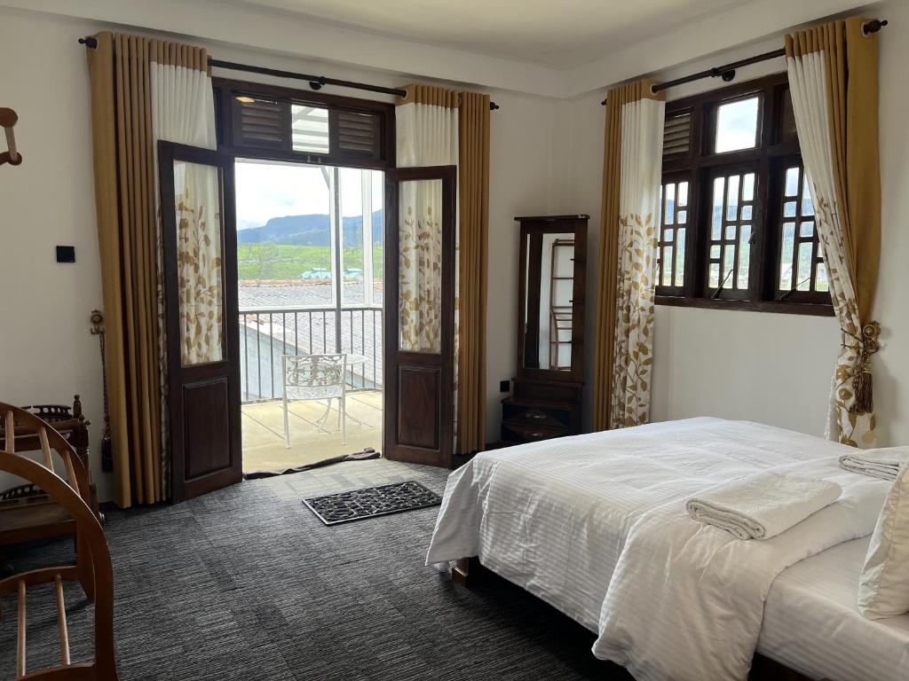 Schlafzimmer mit einem Bett und Schiebetüren mit einem Balkon in der Unterkunft AGP home in Nuwara Eliya