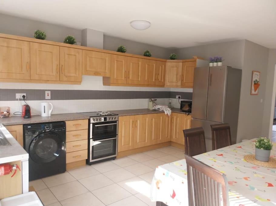 a kitchen with wooden cabinets and a stove and a table at Beautiful home kenmare in Kenmare