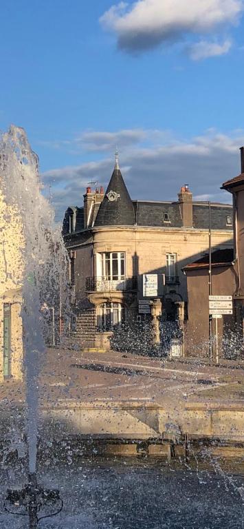 un vieux bâtiment avec une fontaine devant dans l'établissement La Renardière, à Neufchâteau