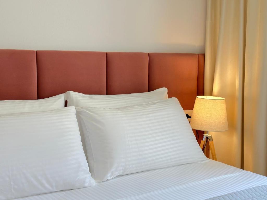 a bed with white pillows and a brown headboard at Cozy Nest Golem in Golem