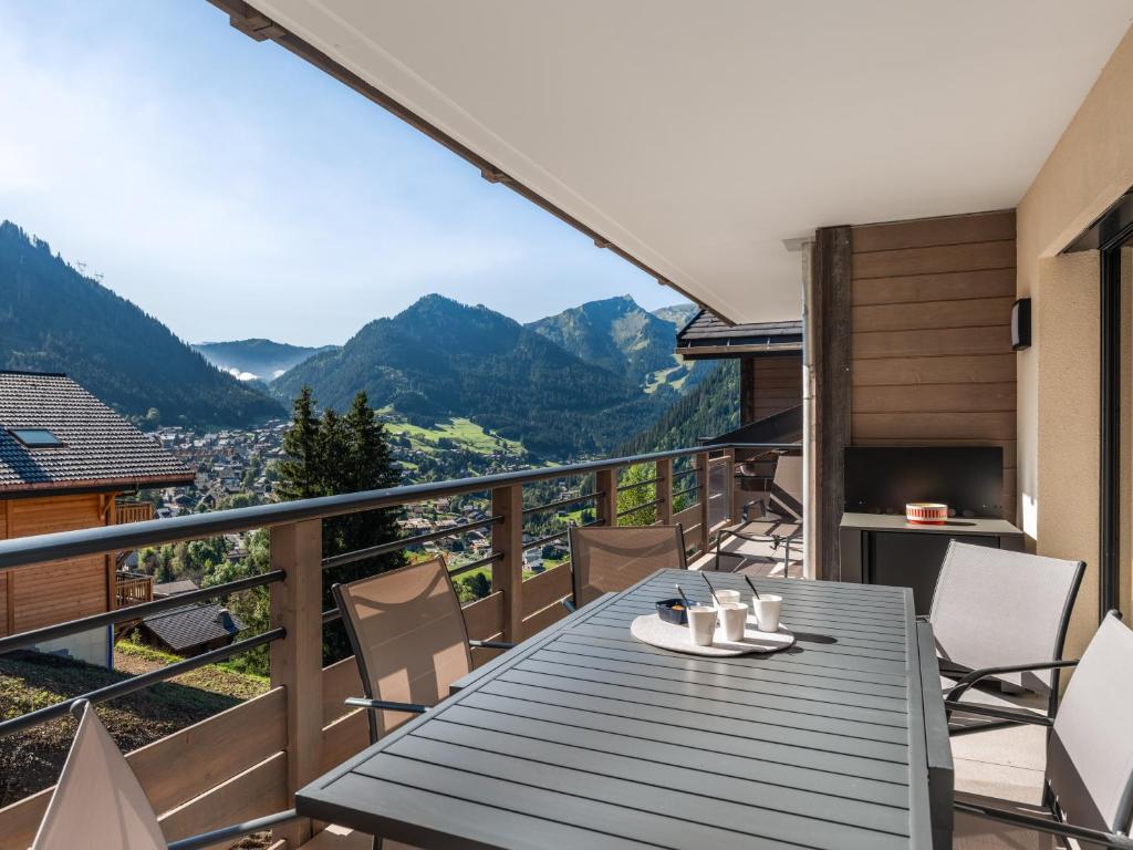 d'un balcon avec une table, des chaises et des montagnes. dans l'établissement Le Thélème 401 - Châtel - Bo Immobilier - Multipass été 2025 offert, à Châtel