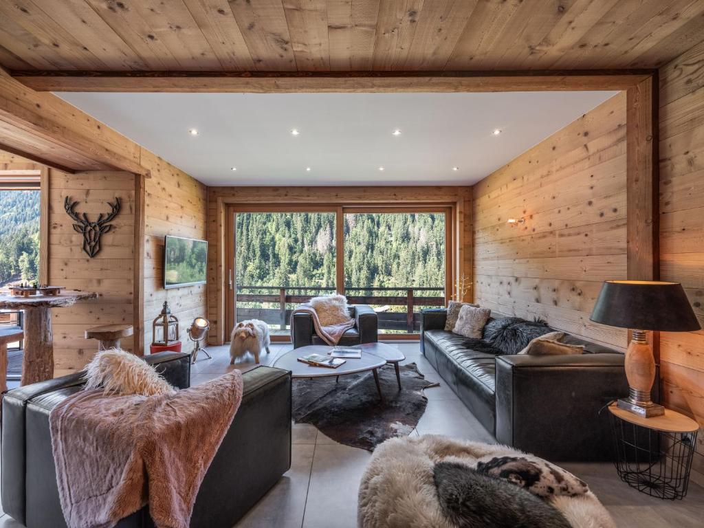 a living room with leather furniture and wood walls at Chalet 1100 - Bo Immobilier Chatel - à mi-chemin du centre et du Linga - jacuzzi sauna et cheminée in Châtel