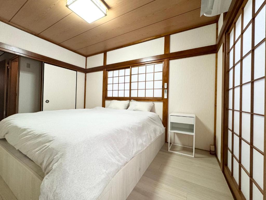 东京Family House 蕾 池袋徒步圈全新装修日式户建民宿的带一张白色大床和窗户的卧室