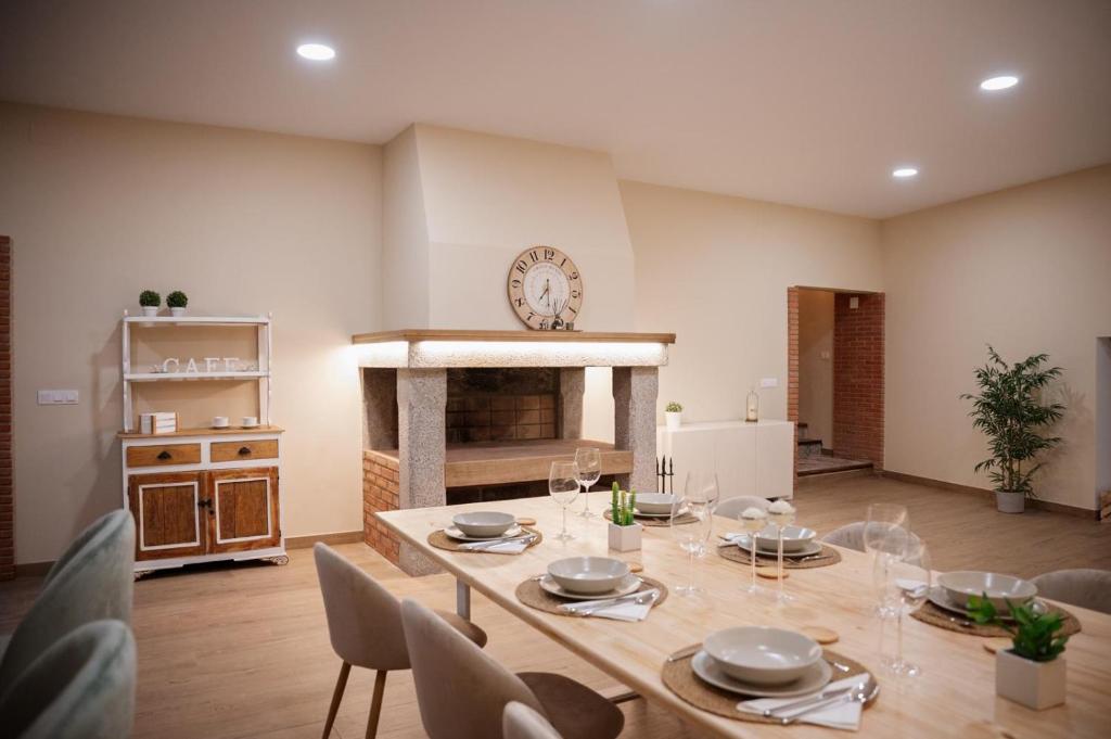a dining room with a table and a fireplace at El gallinero de la abuela Claudia in Aldea de Trujillo