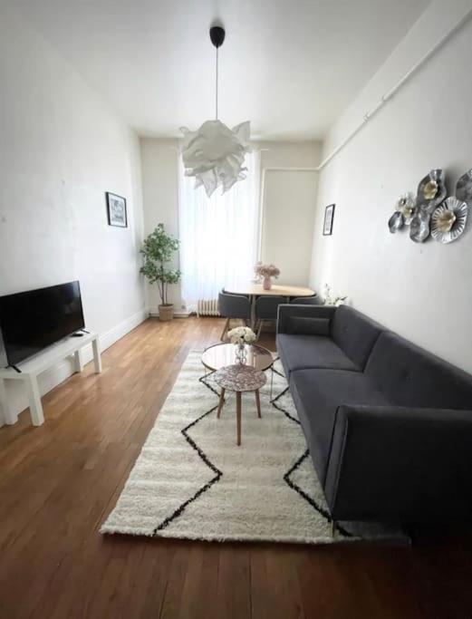 un salon avec un canapé et une table dans l'établissement Appartement Brunard, à Lyon