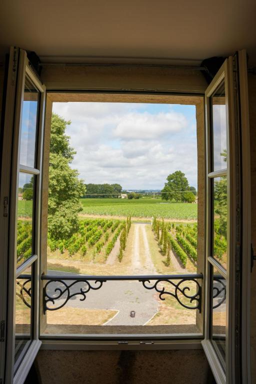 an open window with a view of a vineyard at Château Vieux Clos Saint Émilion in Saint-Émilion